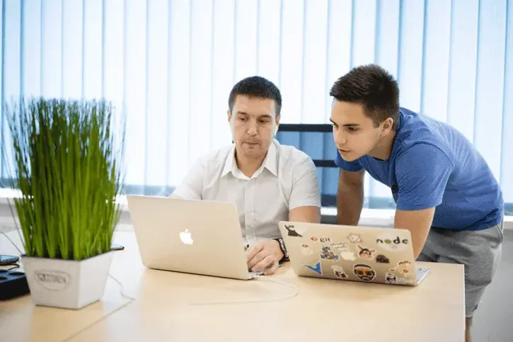 the software development lead is demonstrating project to his teammate on the screen