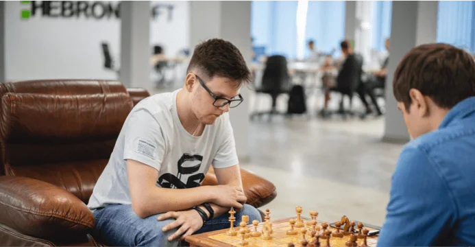 two software engineers playing chess at the open space of HebronSoft during their relax time